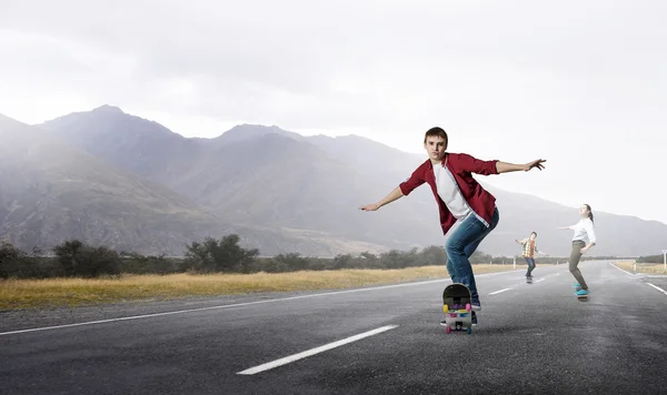 Giovani che cavalcano skateboard — Foto Stock