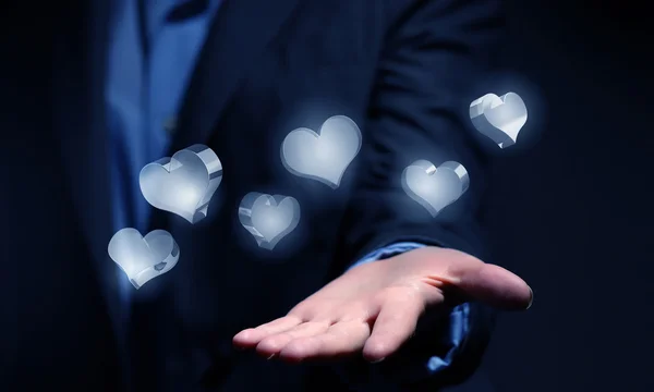 Ícones de vidro do coração na palma da mão — Fotografia de Stock