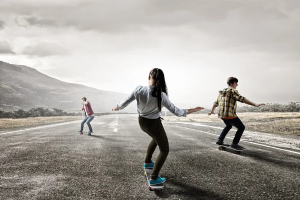 Giovani che cavalcano skateboard — Foto Stock