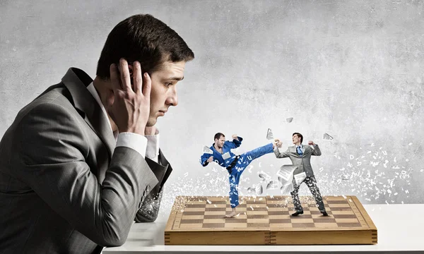 Бизнесмен сражается на шахматной доске — стоковое фото