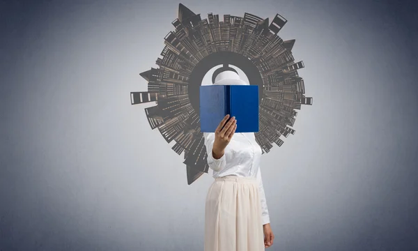 Frau versteckt Gesicht hinter Buch — Stockfoto