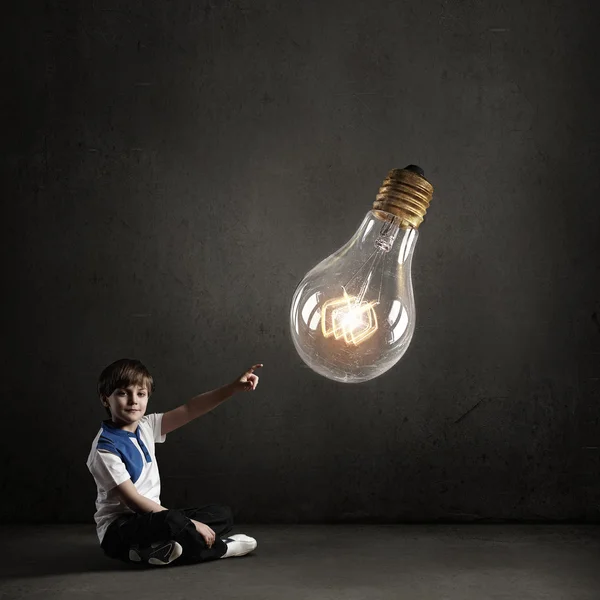 Boy pointing light bulb — Stock Photo, Image