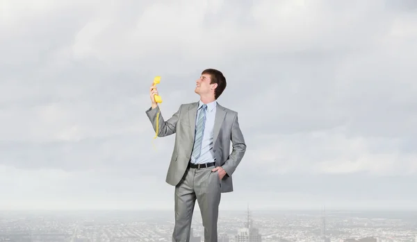 Empresário com receptor amarelo — Fotografia de Stock