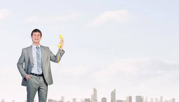 Businessman with yellow receiver — Stock Photo, Image