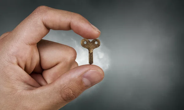 Key between fingers — Stock Photo, Image