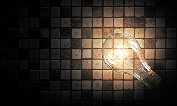Light bulb op baksteen oppervlak — Stockfoto