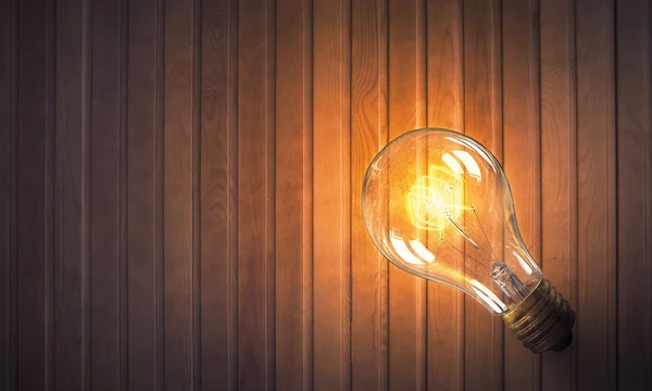 Lampu pijar di permukaan kayu — Stok Foto