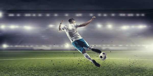 Футболист бьет по мячу — стоковое фото