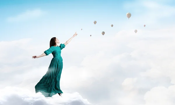 Vrouw in bewolkte hemel — Stockfoto