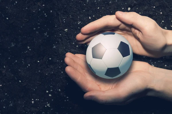 Soccer ball in palms — Stock Photo, Image