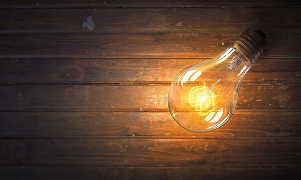 Light bulb op houten oppervlak — Stockfoto