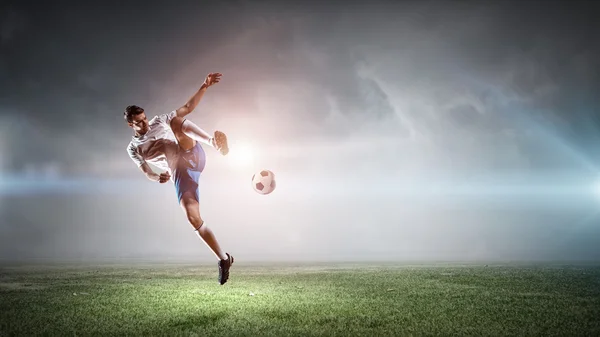 Giocatore di calcio che colpisce palla — Foto Stock