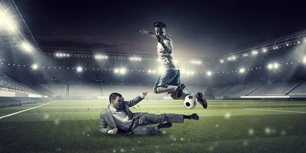 Бизнесмен и игрок, борющийся за мяч — стоковое фото
