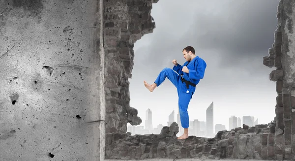 Hombre en kimono rompiendo pared —  Fotos de Stock