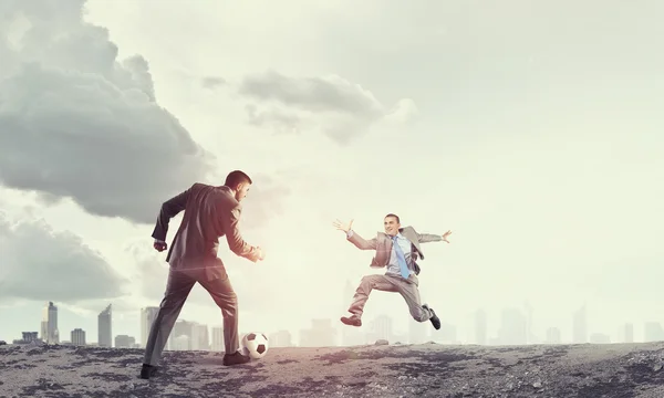 Businessman kicking ball — Stock Photo, Image