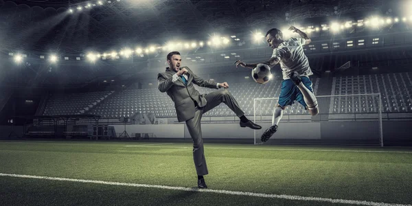 Homme d'affaires et joueur se battant pour le ballon — Photo