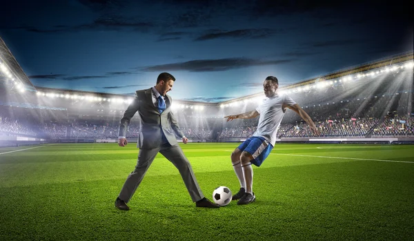 Бізнесмен і гравець бореться за м'яч — стокове фото