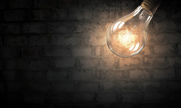 Light bulb op baksteen oppervlak — Stockfoto