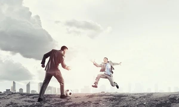 Businessman kicking ball — Stock Photo, Image