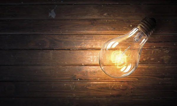 Light bulb op houten oppervlak — Stockfoto