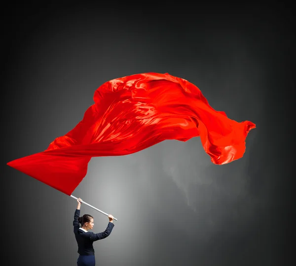 Женщина машет красным флагом — стоковое фото