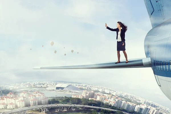 Frau auf Flugzeugflügel hoch am Himmel — Stockfoto