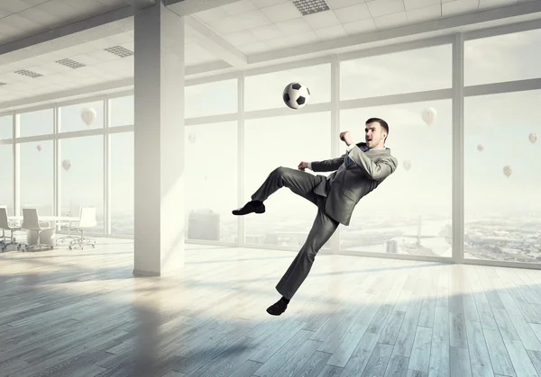 Spela fotboll i office. Mixed media — Stockfoto