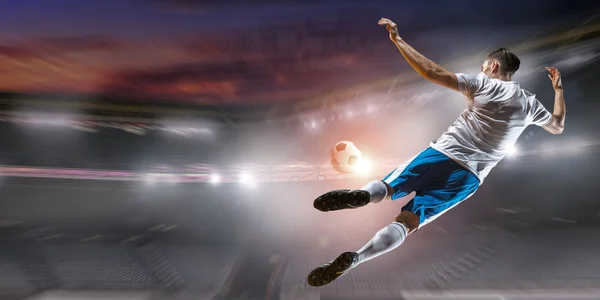 Soccer player hitting ball . Mixed media — Stock Photo, Image