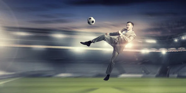 Hombre de negocios pateando la pelota. Medios mixtos —  Fotos de Stock