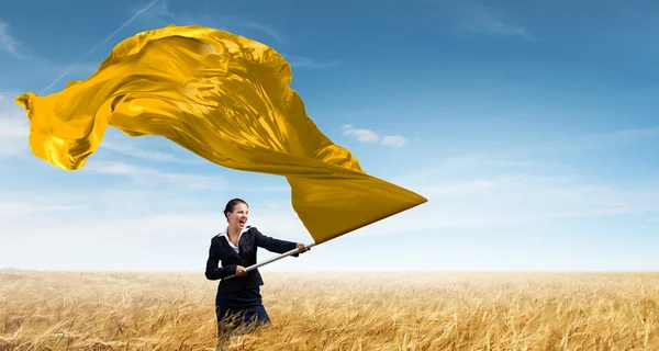 Mujer ondeando bandera amarilla. Medios mixtos — Foto de Stock