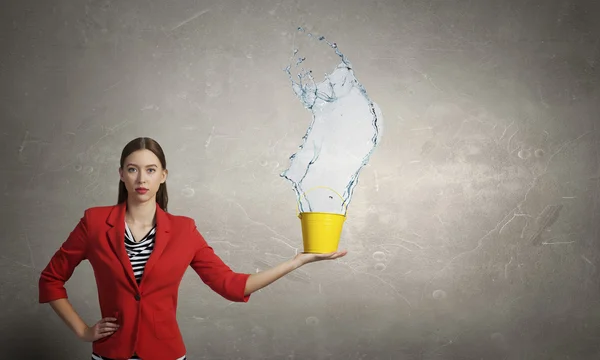 Ragazza che versa acqua dal secchio. Mezzi misti — Foto Stock