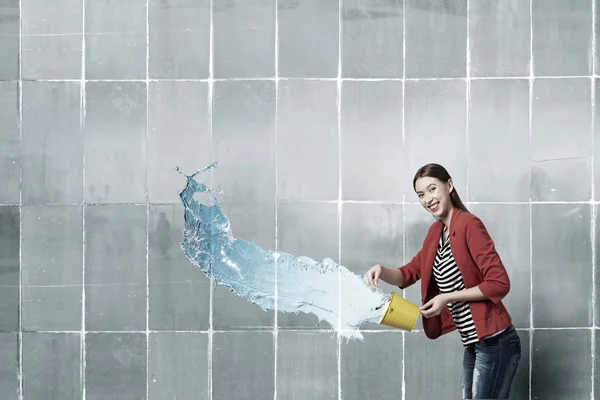 Девушка наливает воду из ведра. Смешанные медиа — стоковое фото