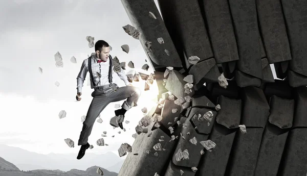 Businessman crashing bricks . Mixed media — Stock Photo, Image