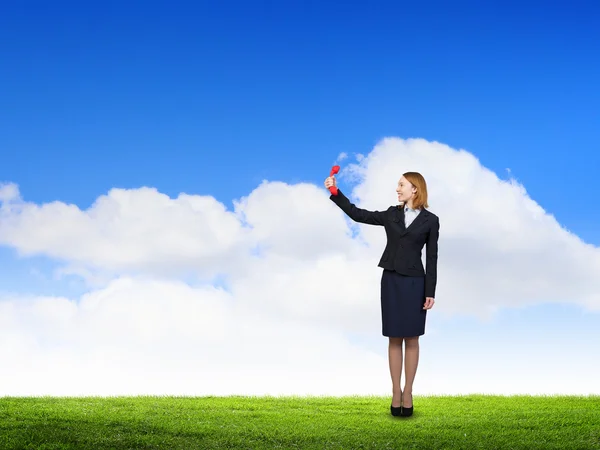 Woman holding red phone handset . Mixed media — Stock Photo, Image