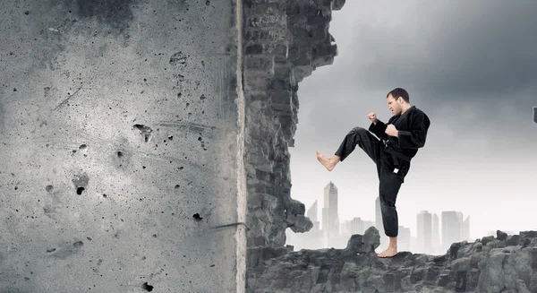 Hombre en kimono rompiendo la pared. Medios mixtos — Foto de Stock