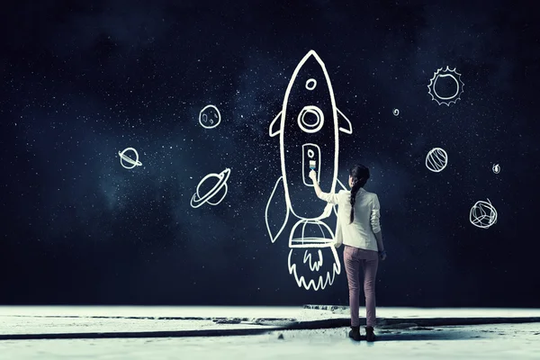 Girl drawing rocket . Mixed media — Stock Photo, Image