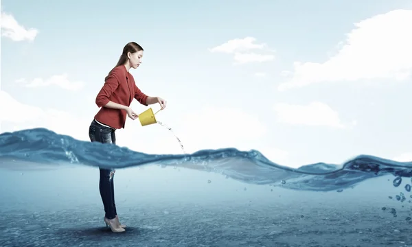 Une fille qui verse de l'eau du seau. Techniques mixtes — Photo