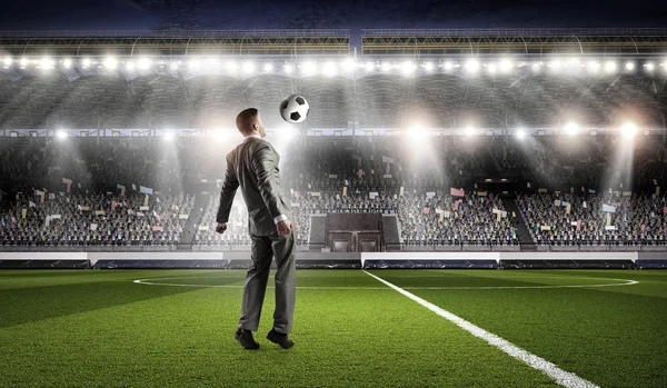 Hombre de negocios pateando la pelota. Medios mixtos — Foto de Stock