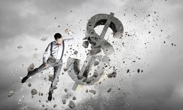 Man attacking dollar symbol . Mixed media — Stock Photo, Image