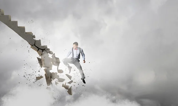 Man breaking ladder . Mixed media — Stock Photo, Image