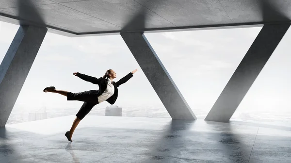 Dancing businesswoman in office . Mixed media — Stock Photo, Image