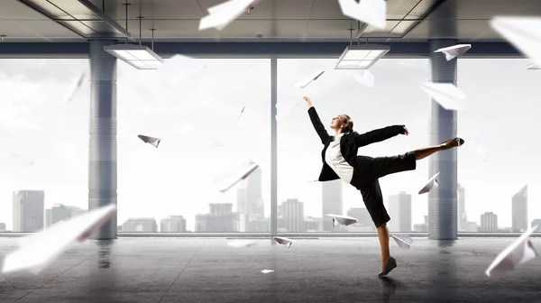 Dancing businesswoman in office . Mixed media — Stock Photo, Image