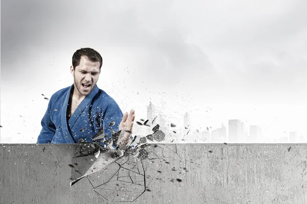 Hombre en kimono rompiendo la pared. Medios mixtos — Foto de Stock