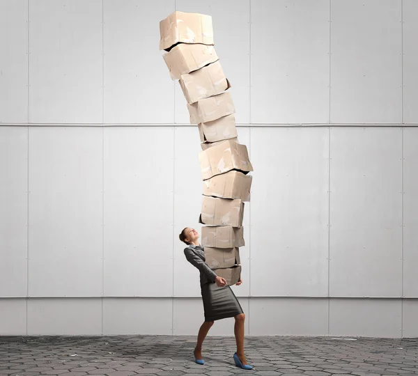 Woman carrying carton boxes . Mixed media — Stock Photo, Image