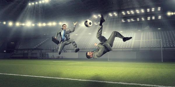 Two businessmen fight for ball . Mixed media — Stock Photo, Image