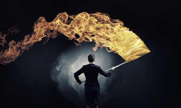 Woman waving yellow flag . Mixed media — Stock Photo, Image