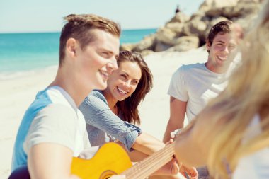 Sahilde gitar ile güzel gençler