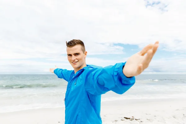 Jonge man in sport slijtage met uitgestrekte armen — Stockfoto