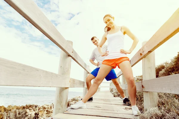 Löpare. Ungt par utövar på stranden — Stockfoto