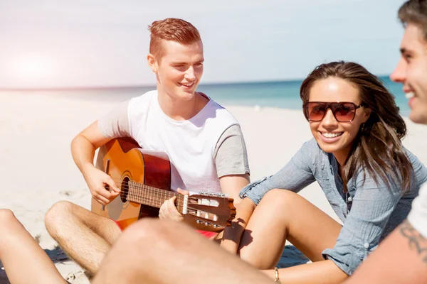 Hermosos jóvenes con guitarra en la playa — Foto de Stock